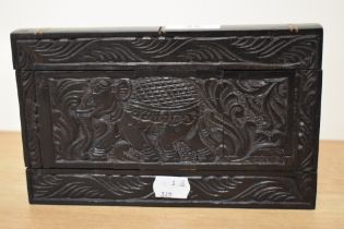 An Asian carved ebony puzzle box of rectangular form with elephant in carved borders.