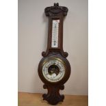 A Victorian wall hanging oak barometer with thermometer.