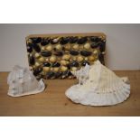 Two natural conch sea shells and a vintage wooden box encrusted with shells.