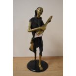 A 20th century African bronze musician figure with patinated garments and circular base and marked B