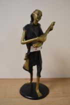 A 20th century African bronze musician figure with patinated garments and circular base and marked B