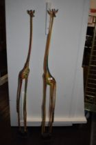 A pair of colourful painted wooden giraffe studies.