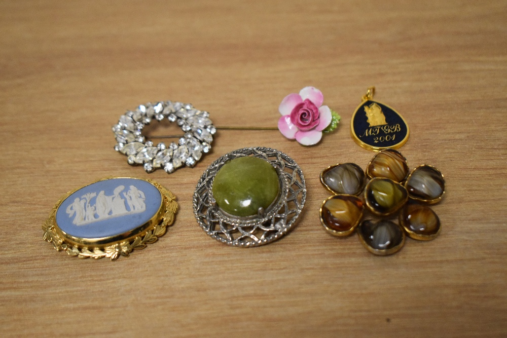 A collection of costume brooches, including a Wedgwood brooch in a decorative mount, a floral