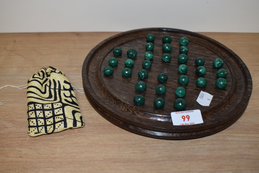 A 20th Century solitaire board, measuring 23cm in diameter, with 34 malachite marbles