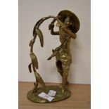 A 20th Century gilt metal study of an African man cutting corn, measuring 18cm tall