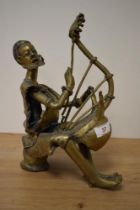 A 20th century Nigerian cast brass musician, playing harp like instrument, approx 29cm high.