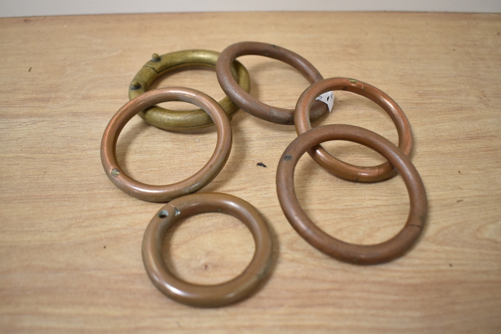 A collection of brass and copper curtain rings