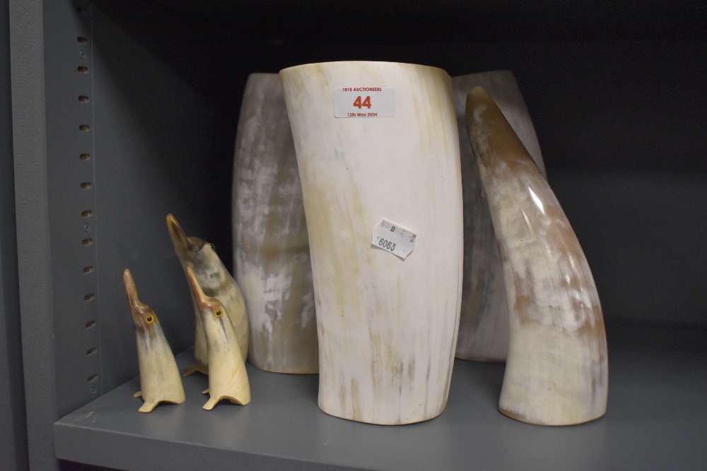 Three large horn vases, three carved horn penguins and another horn.