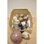 An assorted collection of polished stone decorative eggs and balls, the largest having a diameter of