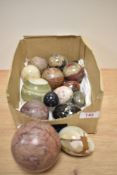 An assorted collection of polished stone decorative eggs and balls, the largest having a diameter of