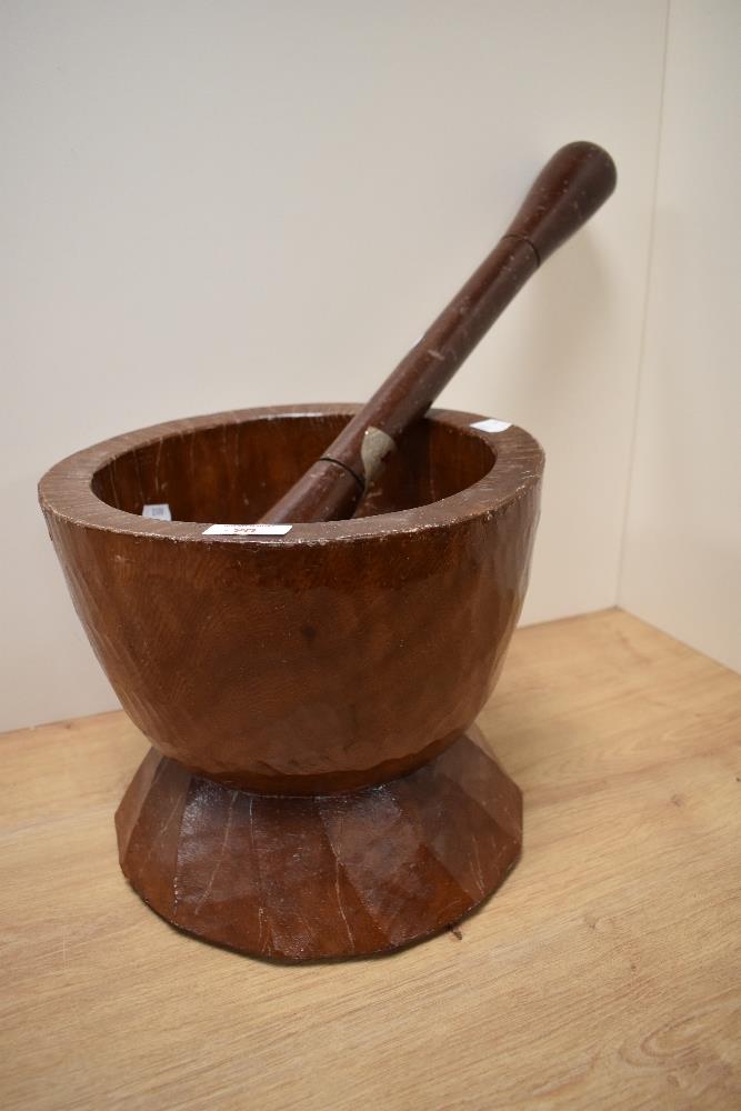 A large floor standing hardwood pestle and mortar.