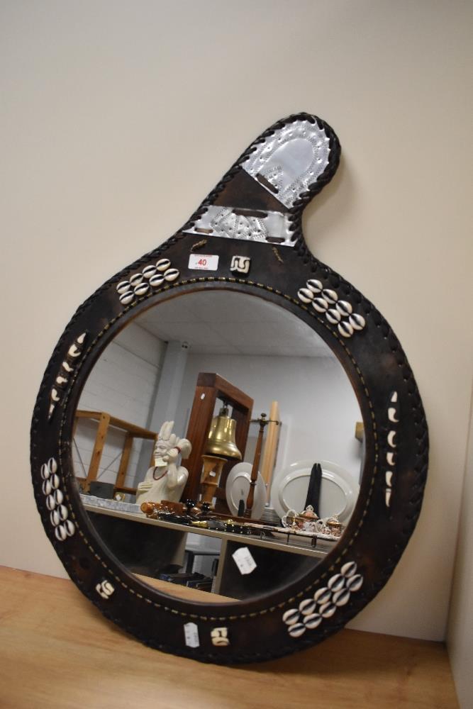 An African leather framed mirror, with shell decoration and beadwork.