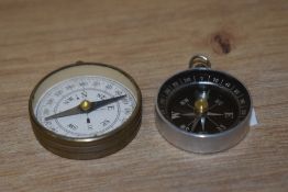 Two small early-mid 20th Century pocket compasses, the largest with a diameter of 4cm