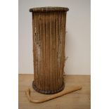 An African talking drum with beater, of typical hour glass form, measuring 46cm tall