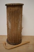 An African talking drum with beater, of typical hour glass form, measuring 46cm tall