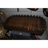 An African carved hardwood plucked idiophone musical instrument profusely carved with repeating