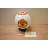 A Danbury Mint Manchester United Champions Trophy Glazed life sized Porcelain Football on display