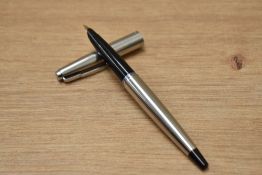 A Parker 45 aero fill fountain pen in stainless steel with black tassie having hooded nib. Nib