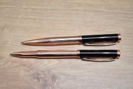 A boxed Stratton rollerball and ballpoint pen set in black and rose gold.