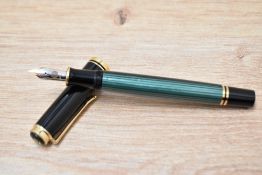 A Pelikan M400 Souveran twist fill fountain pen in green and black with gold trim having Pelikan 14C