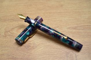 A Conway Stewart Dandy Azure lever fill fountain pen No.106/500 in purple green and purl marble with