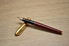 A Parker 75 converter fill fountain pen in burgundy laque with gold cap which has ruby coloured