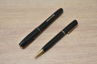 A Waterman (stalwart?) lever fill fountain pen and propelling pen set in dark green with two