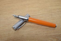 An FPR converter fill fountain pen in quichdra orange and brushed steel cap having FPR F nib