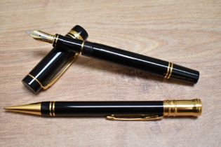 A boxed Parker Doufold International converter fill fountain pen and propelling pencil in black with