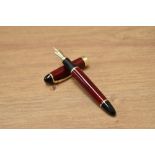 A Ginhao X450 converter fill fountain pen in black and red with gold trim having Ginhao 18K gold