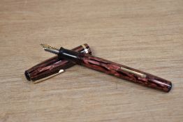 A Wearever De Luxe 100 lever fill fountain pen in rose pink and black striated having 14k USA nib