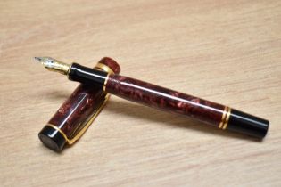 A Parker Duofold International Cartridge fill fountain pen in red swirl with one broad and one
