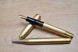 A gold fill, piston fill fountain pen and propelling pencil set in barleycorn pattern having a