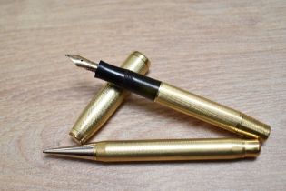 A gold fill, piston fill fountain pen and propelling pencil set in barleycorn pattern having a