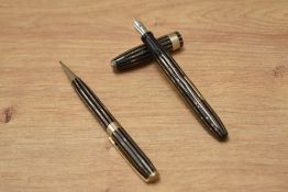 An Arnold lever fill fountain pen and propelling pencil set in brown, bronze and black pin stripe