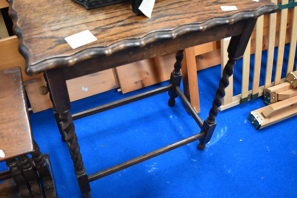 An early 20th Century oak occasional table having shaped top on twist frame, width approx. 59cm,