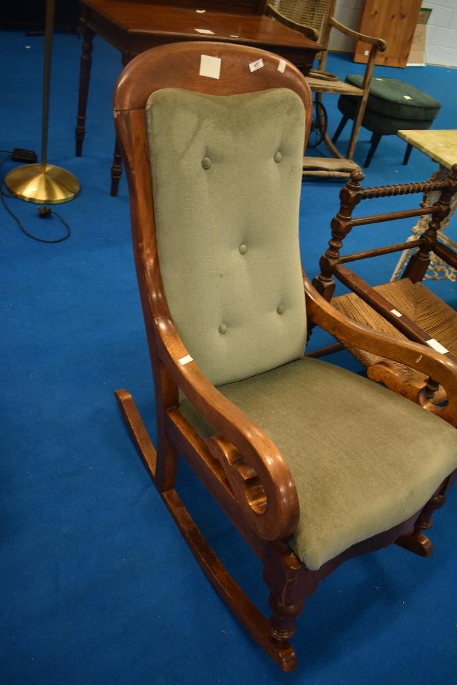 A Victorian mahogany rocking chair having later dralon upholstery