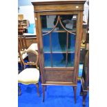 An Edwardian mahogany and inlaid narrow display cabinet having foliate inlay decoration,