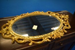 A gilt frame wall mirror having foliate scroll decoration, approx 92 x 57cm
