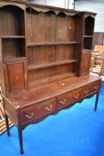 A period oak dresser having delft rack with shelves and cupboards to side , drawers to base on