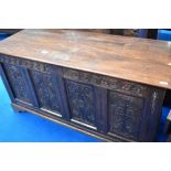 A traditional oak kist having carved panel decoration, approx dimensions W153 D60 H75cm