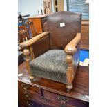 An early 20th Century childs stained frame armchair with leather sides and moquette seat, dimensions