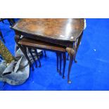 An early to mid 20th Century walnut occasional table and later nest of three period style tables