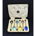 A cased set of George V coffee bean spoons having an Art Deco guilloch enamel design to the