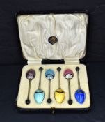 A cased set of George V coffee bean spoons having an Art Deco guilloch enamel design to the