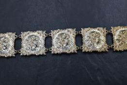 An Art Nouveau silver plated articulated belt and buckle, each square panel cast with a cherubs