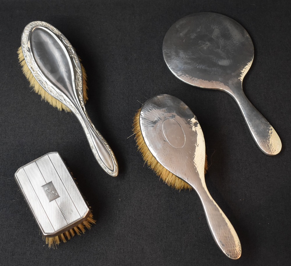 An Edwardian two-piece silver dressing table set, comprising a hairbrush and mirror having planished