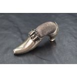 A late Victorian silver novelty pin cushion modelled as a shoe with a decorative buckle, having dark