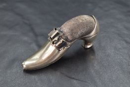 A late Victorian silver novelty pin cushion modelled as a shoe with a decorative buckle, having dark