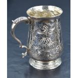 A George III silver tankard of baluster form, having a slightly flared rim and scroll handle, raised